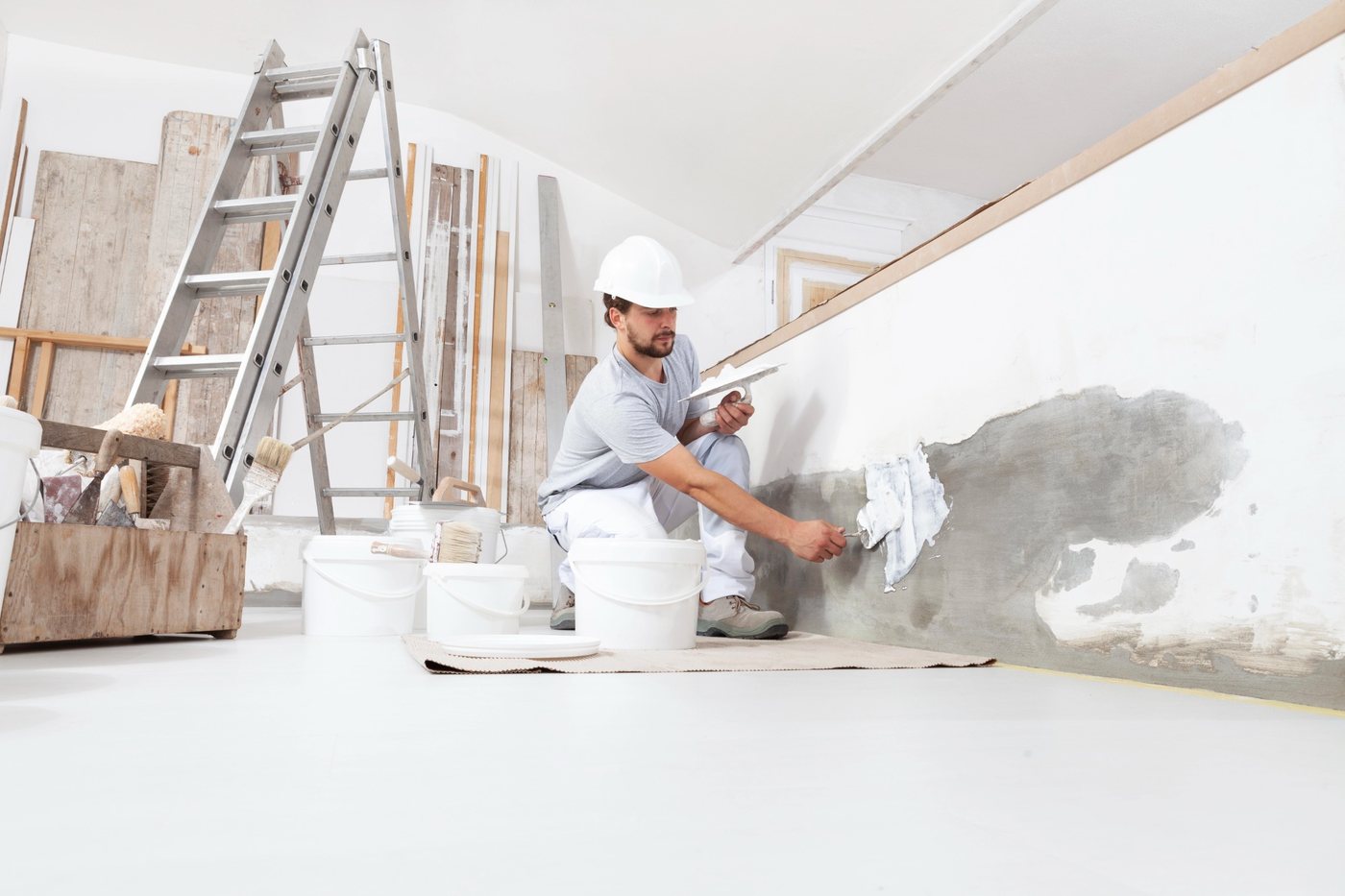 Kleine Schadstelle in einer Wand wird vor dem Anstrich verspachtelt